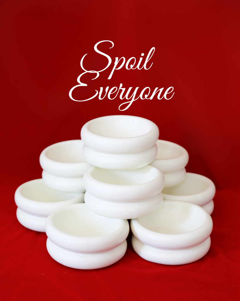 Stack of white cat bowls with 'Spoil Everyone' text on a red background