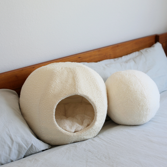 modern white boucle cat cave and cat bed on modern home bed with round ball cushion pillow very aesthetic by catenary is like a cat igloo, cat nest and cat hideaway all in one
